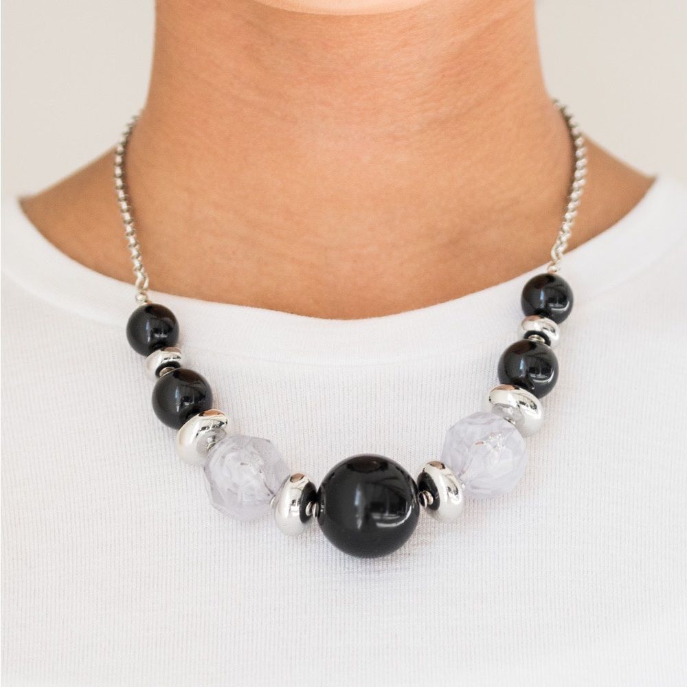 Large black bead and white bead on silver tone chain with earrings
